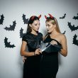 Dwie kobiety w halloweenowej stylizacji z nietoperzami w tle – promocja Dolores na darmowe ogłoszenia do końca października